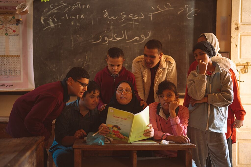 Alumnos con necesidades educativas especiales leen junto a su maestra en un aula (imagen genérica, tomada en Egipto)