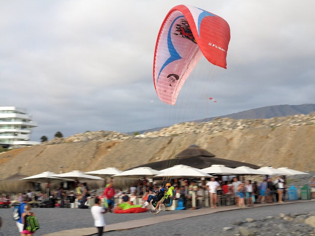 Un parapente biplaza aterriza junto a la playa de La Caleta, en Adeje (imagen de archivo)