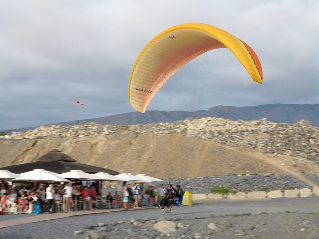 Parapentes aterrizando en la playa de La Caleta, en Adeje